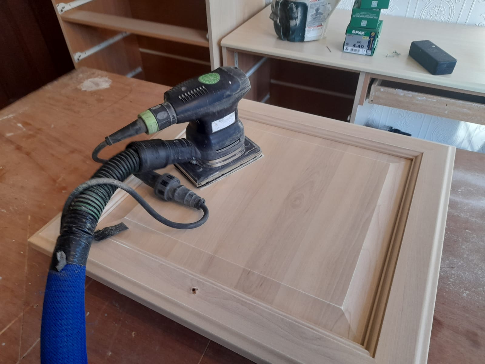 Photo of a decorators professional 99% dust free sander being used to sand down a kitchen cabinet ready for the kitchen to be hand painted Photo of a decorators professional 99% dust free sander being used to sand down a kitchen cabinet ready for the kitchen to be hand painted